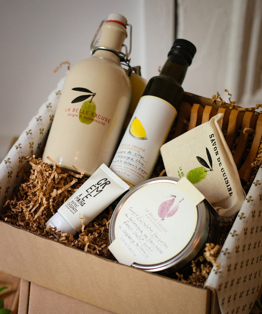 La Belle Excuse Gourmet Gift Set featuring a ceramic cruet filled with green olive oil, lemon and white balsamic vinegar, French shallot confit, kitchen soap with a soap dish, and olive oil hand cream.