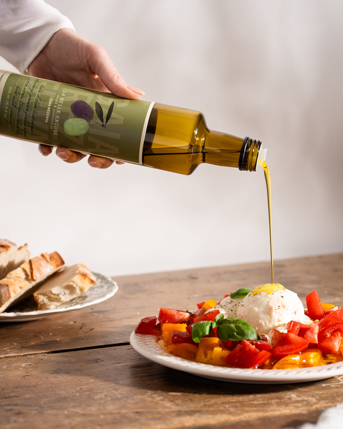 La Belle Excuse Gaïa Rezerva Organic Extra Virgin Olive Oil, in 500 ml, being poured onto a burrata.