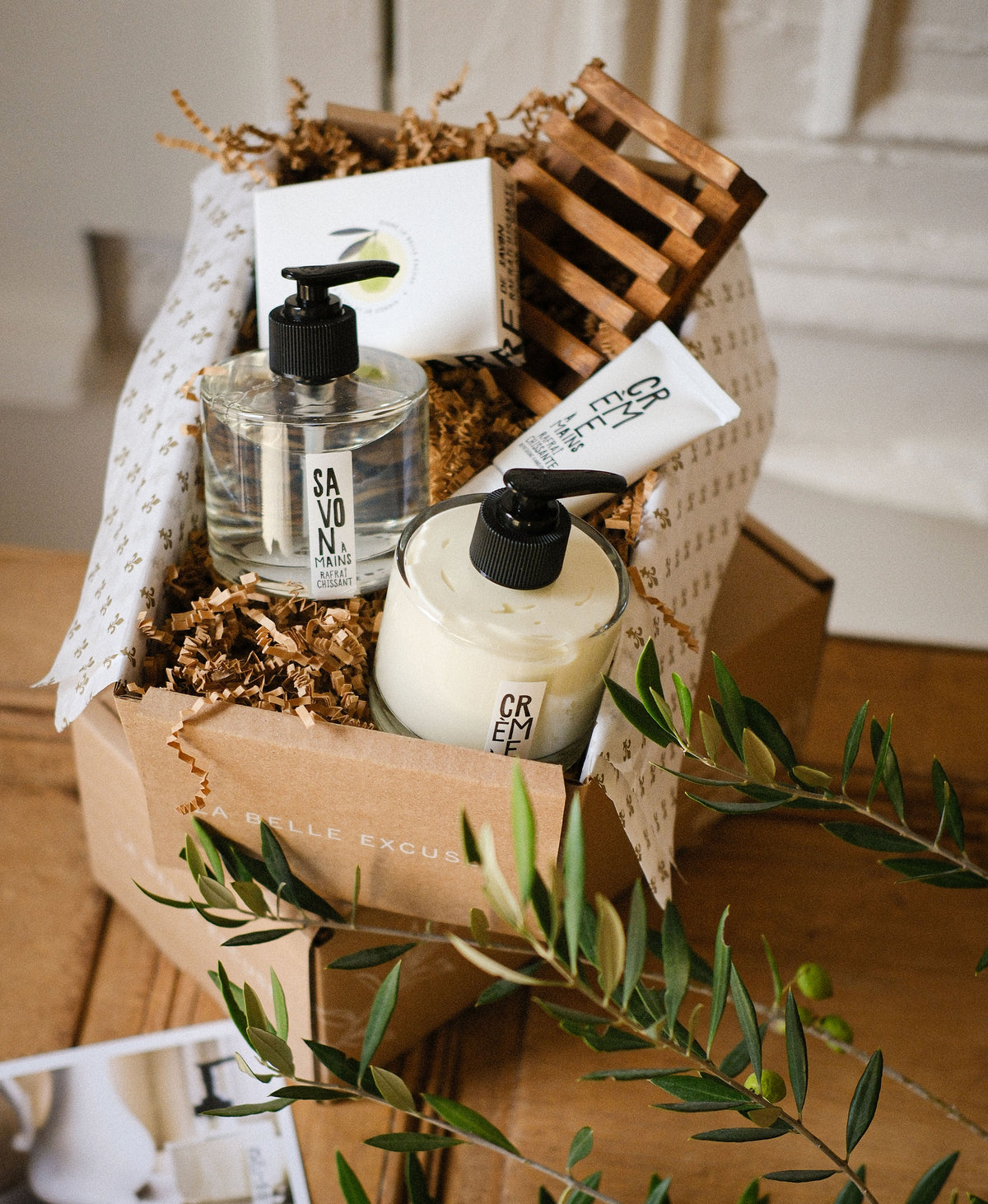 La Belle Excuse Soft Skin Gift Set featuring hand soap, hand cream, exfoliating sea salt soap, travel-size hand cream, and a wooden soap dish.