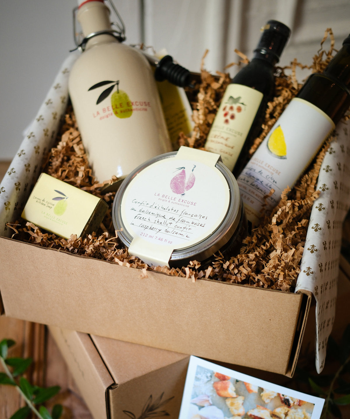 La Belle Excuse Host & Hostess Gift Set featuring a ceramic decanter with 500 ml of green extra virgin olive oil, 250 ml balsamic vinegar, balsamic glaze, and a jar of confit.