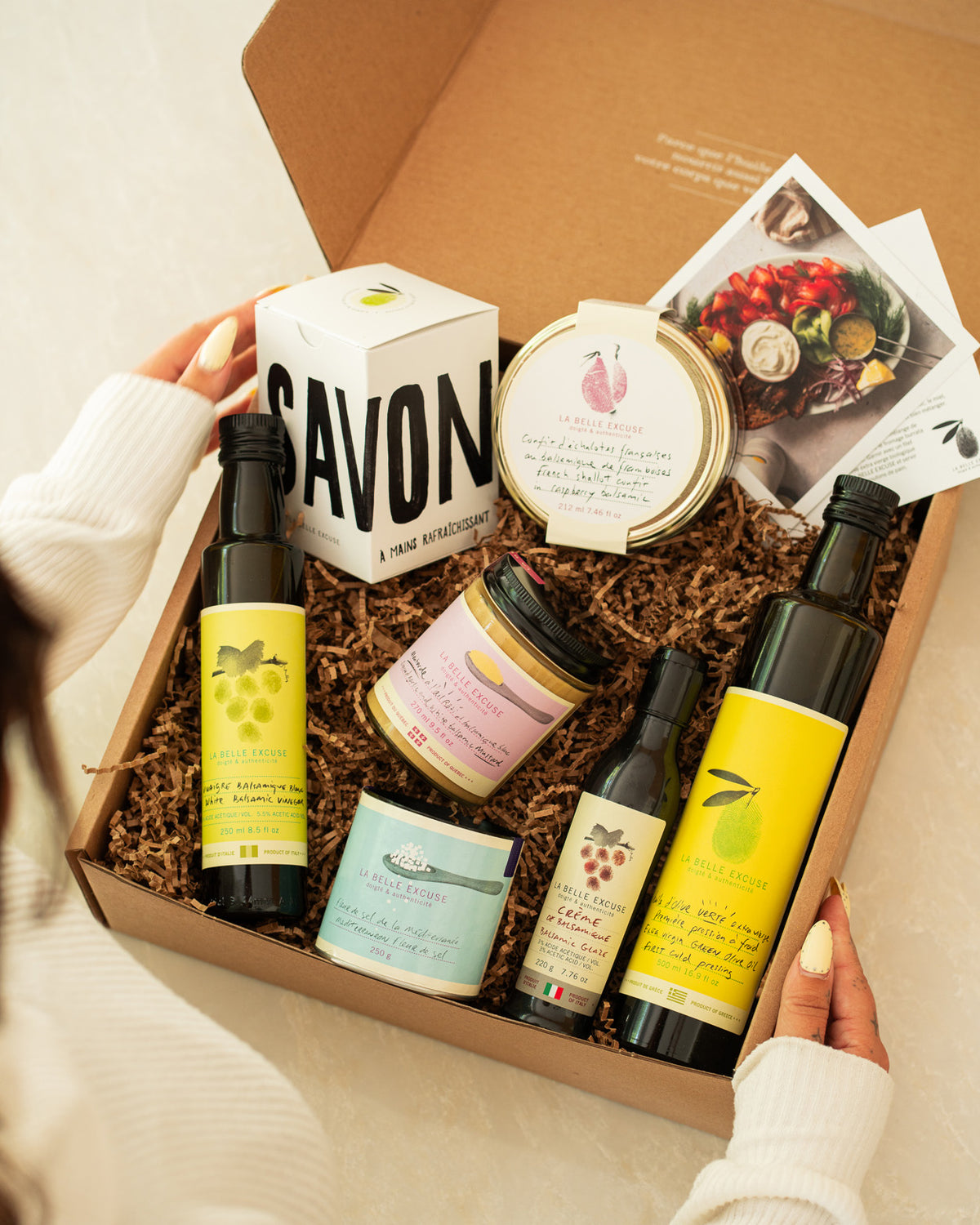 La Belle Excuse Signature Gift Box featuring green extra virgin olive oil, white balsamic vinegar, balsamic glaze, French shallot confit, roasted garlic mustard, Mediterranean fleur de sel, and refreshing hand soap.