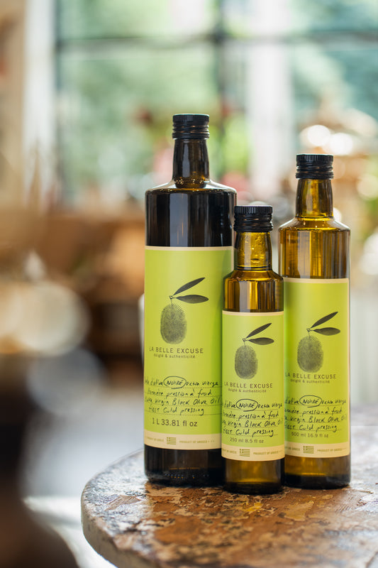 Three formats of La Belle Excuse Extra Virgin Black Olive Oil, made with Greek olives: 250 ml, 500 ml, and 1 L.
